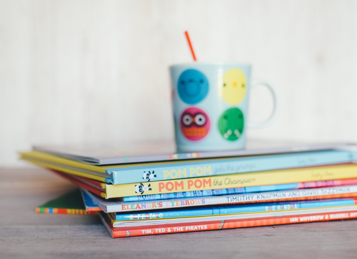 childrens booked stacked with sippy cup on top